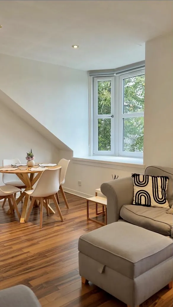 Light living and dining room under a sloping ceiling with a bay window