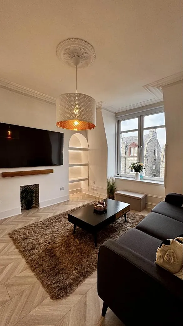 Living room with a statement pendant, arched alcove and granite views