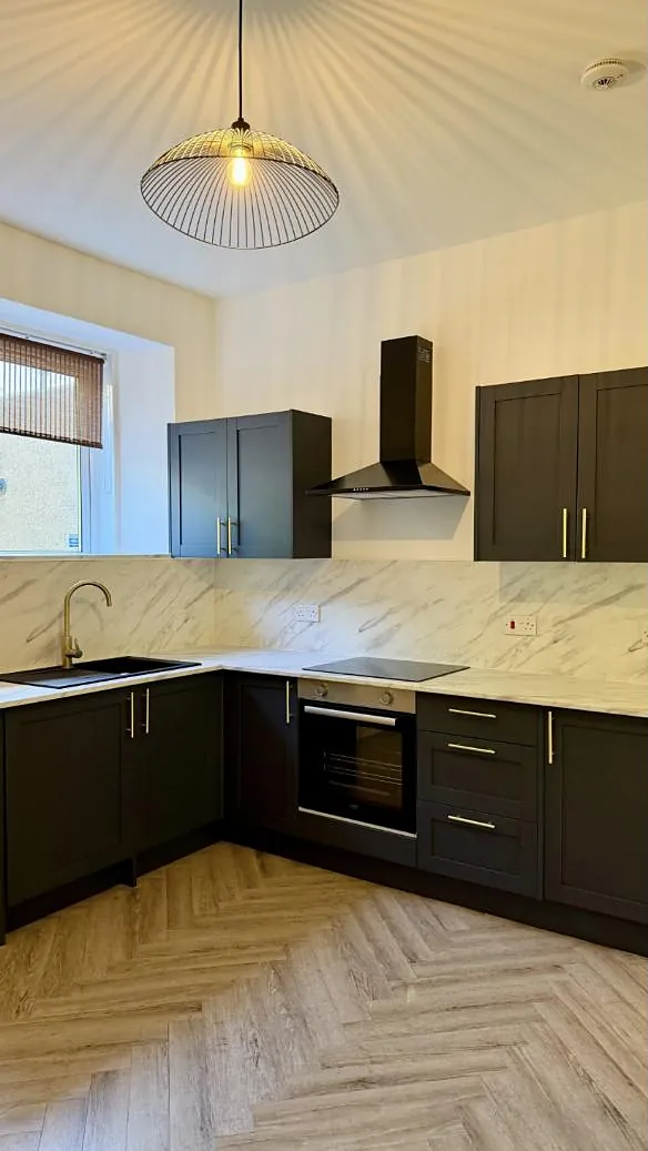 Charcoal shaker kitchen with brass handles, marble splashback and herringbone floor